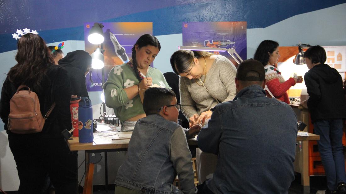 A group of people using a workshop table to build crafts