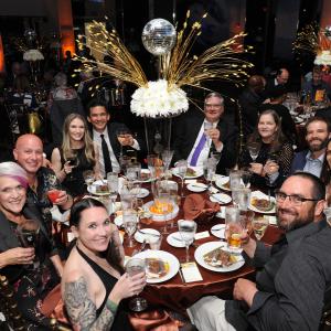 A group of people toasting around a fancy table